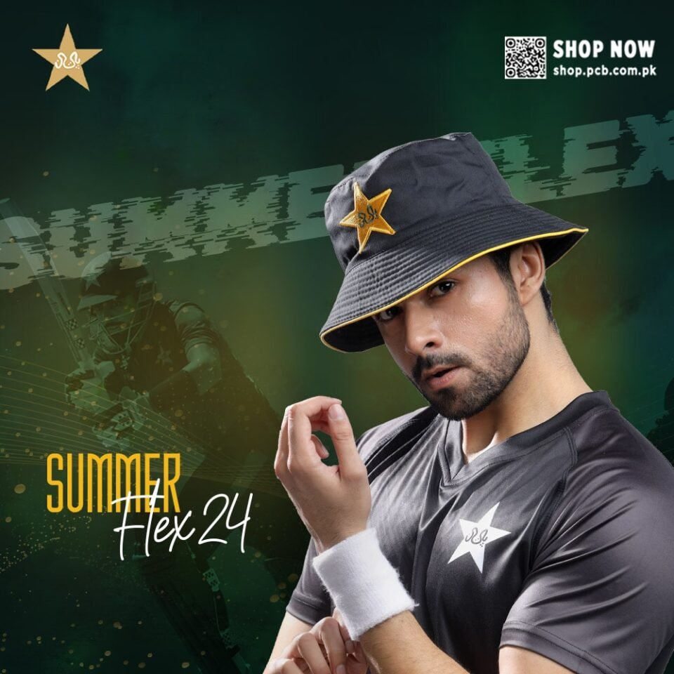 A close-up, moody editorial fashion shot of a South Asian man wearing a dark grey bucket hat with yellow piping and a gold Pakistan Cricket Board (PCB) star logo. He is also wearing a black training shirt with a white PCB star logo and a white wristband. He is looking directly at the camera with an intense expression. The background is a dramatic, dark green with "SUMMER FLEX 24" text. Editorial fashion photography by AHSANZ.